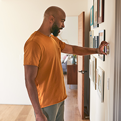 Person adjusting their thermostat.